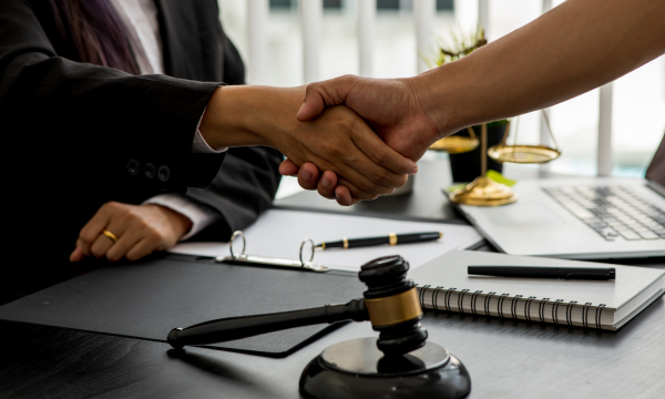 Aperto de mãos entre advogado e cliente simbolizando parceria estratégica de marketing para advogados.