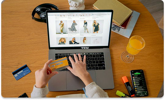 Pessoa realizando compra em loja virtual pelo notebook, com cartão de crédito à mão, representando e-commerce profissional e vendas online 24 horas por dia.